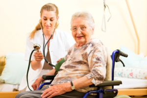 nurse checking the blood pressure of elderly woman